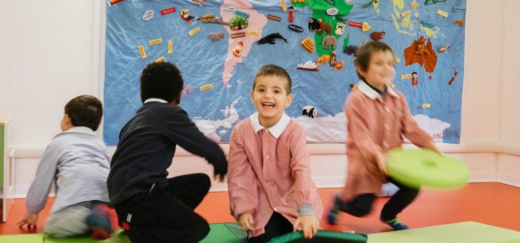 Alcuni bambini sorridenti nella stanza di Spazio ZeroSei con il pavimento rosso