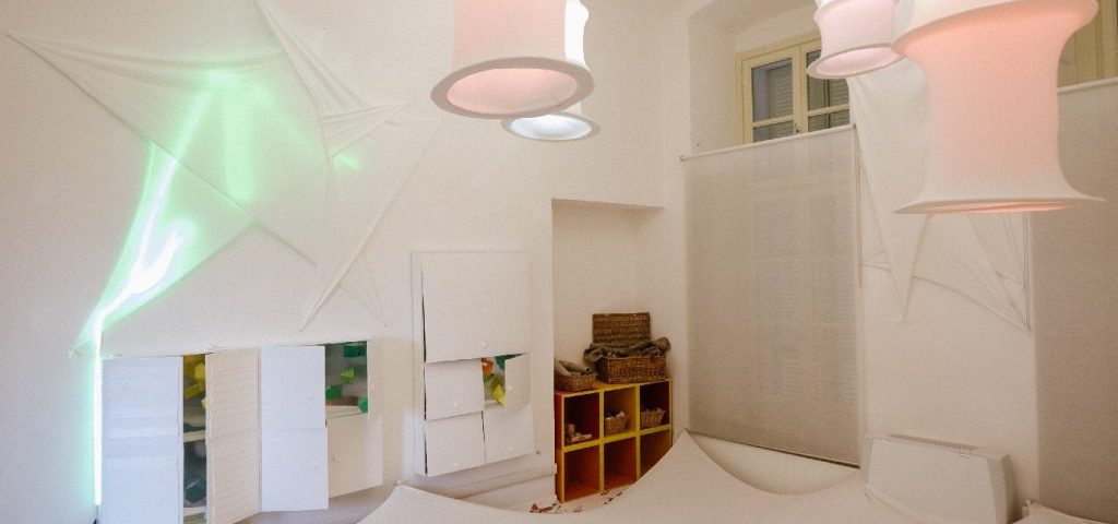 Una stanza tutta bianca: pareti, lampadari, pavimento