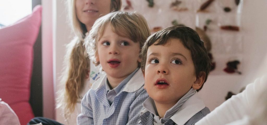 Due bambini e un'insegnante sorridono