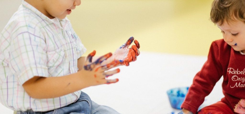 Due bambini con le mani sporche di pittura