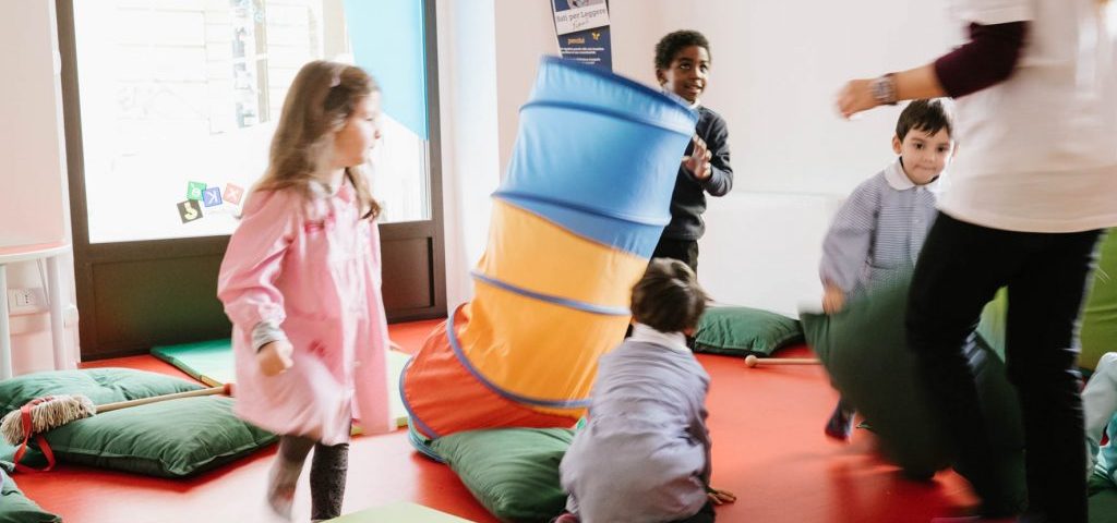 Un gruppo di bambini gioca nella stanza col pavimento rosso di Spazio ZeroSei