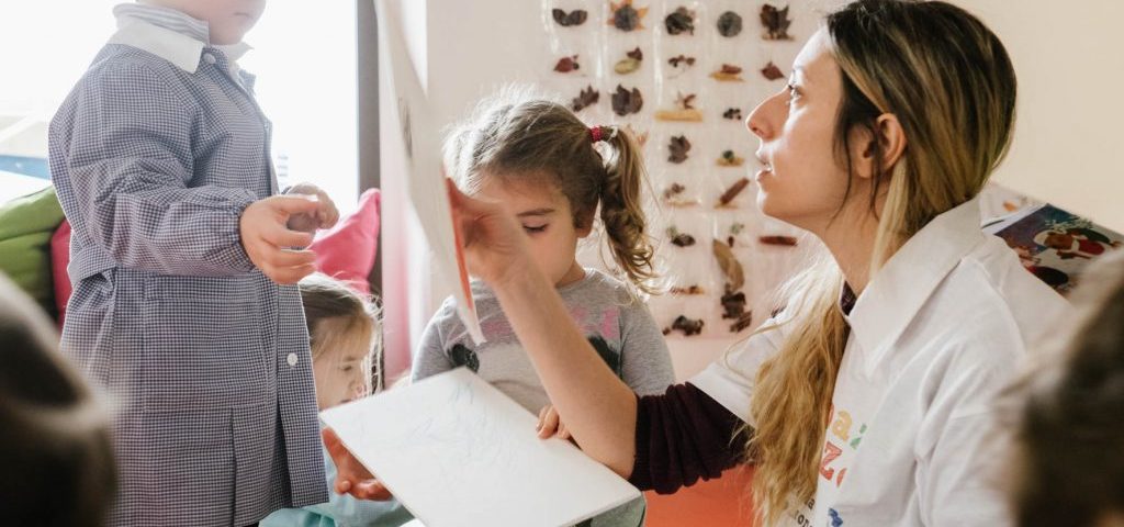 Un bambino e una bambina con un'insegnante in una stanza di Spazio ZeroSei