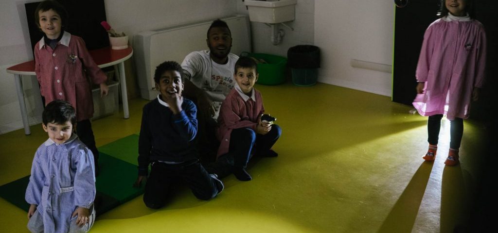 Un gruppo di bambini in una stanza semi buia guarda le ombre