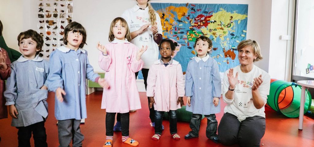 Un gruppo di bambini con due insegnanti muove le mani per formare ombre