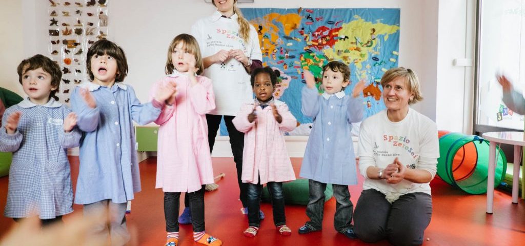 Un gruppo di bambini con due insegnanti che muovono le mani per formare ombre