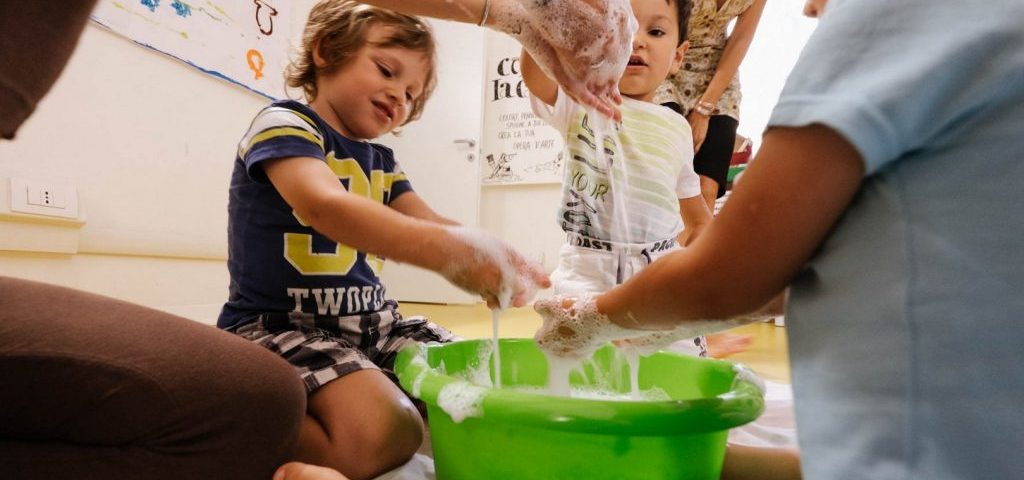 Bambini giocano con acqua e sapone