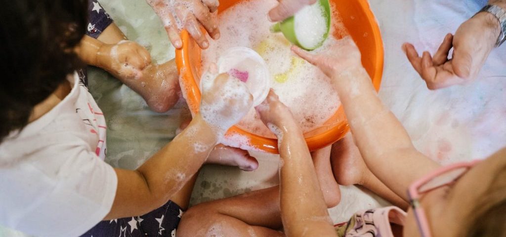 Bambini giocano con acqua e sapone