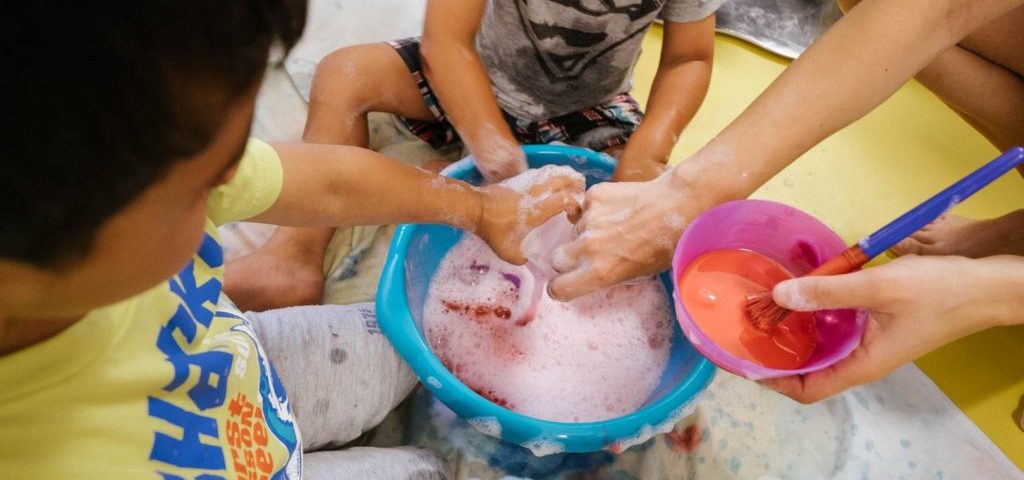 Bambini giocano con acqua e sapone