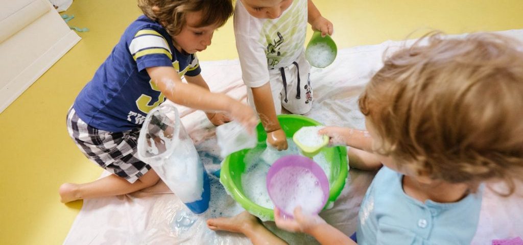 Bambini giocano con acqua e sapone