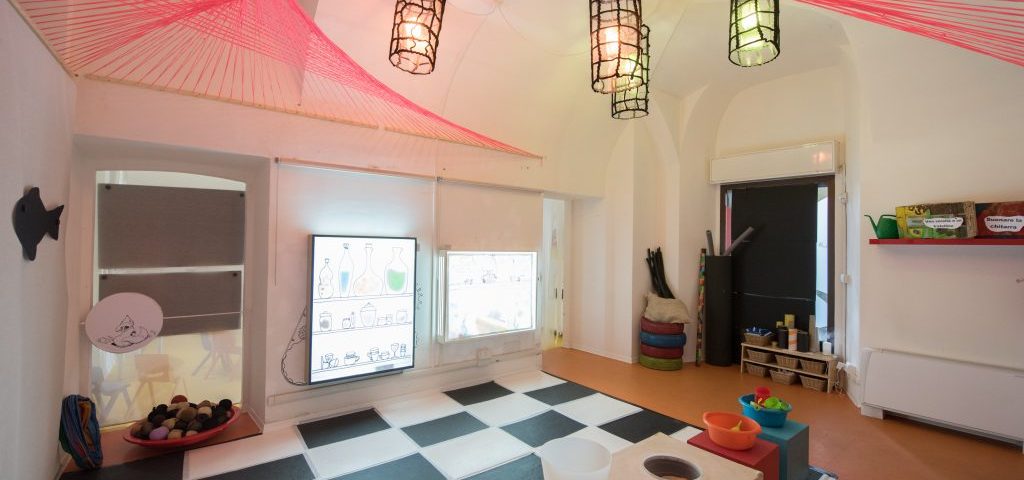 Sala allestita con lanterne che pendono dal soffitto, un pavimento che sembra una scacchiera alternando quadretti bianchi e neri
